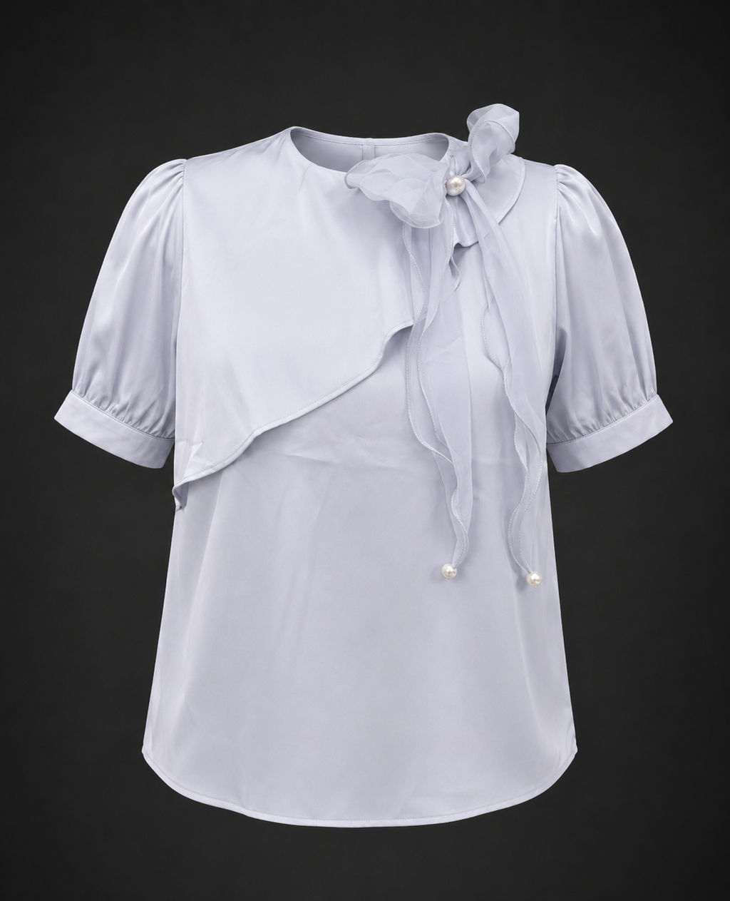 Light blue blouse with ruffled sleeves and a bow on a black background