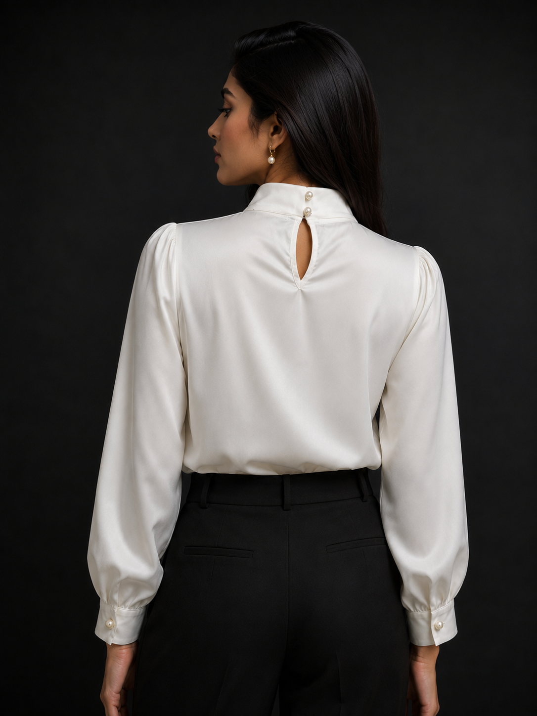 Woman wearing a white blouse with a cutout back design on a black background