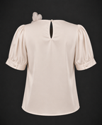Beige blouse with puff sleeves on a black background