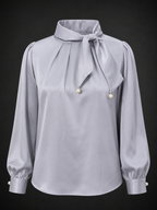 Light gray blouse with a bow neckline on a black background