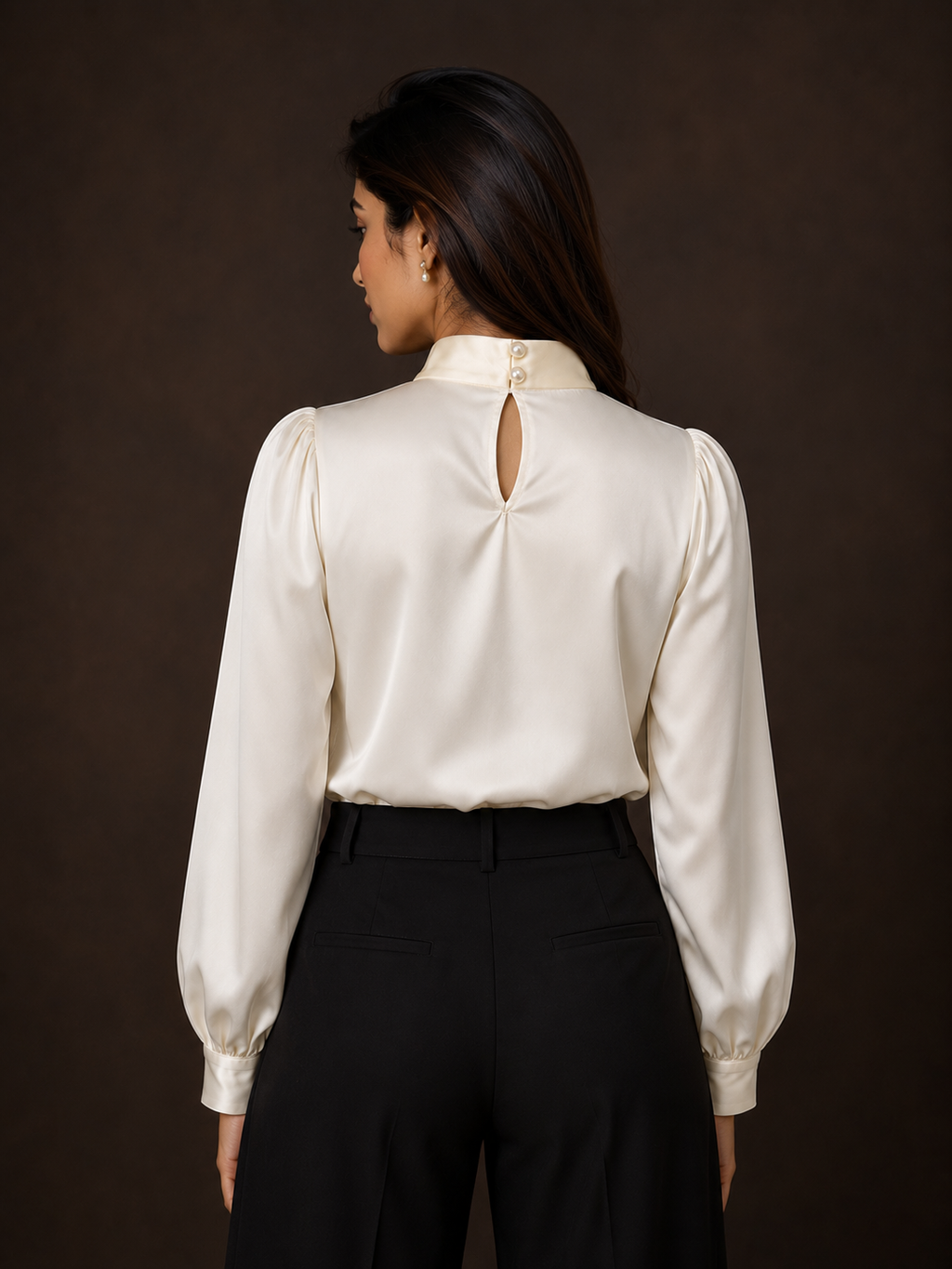 Woman wearing a white blouse with a cutout back design on a dark background
