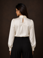 Woman wearing a white blouse with a cutout back design on a dark background
