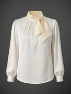 White blouse with long sleeves and a beige scarf on a dark background
