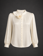 White blouse with ruffled collar and floral detail on a dark background