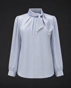 Light blue blouse with a bow neckline on a black background