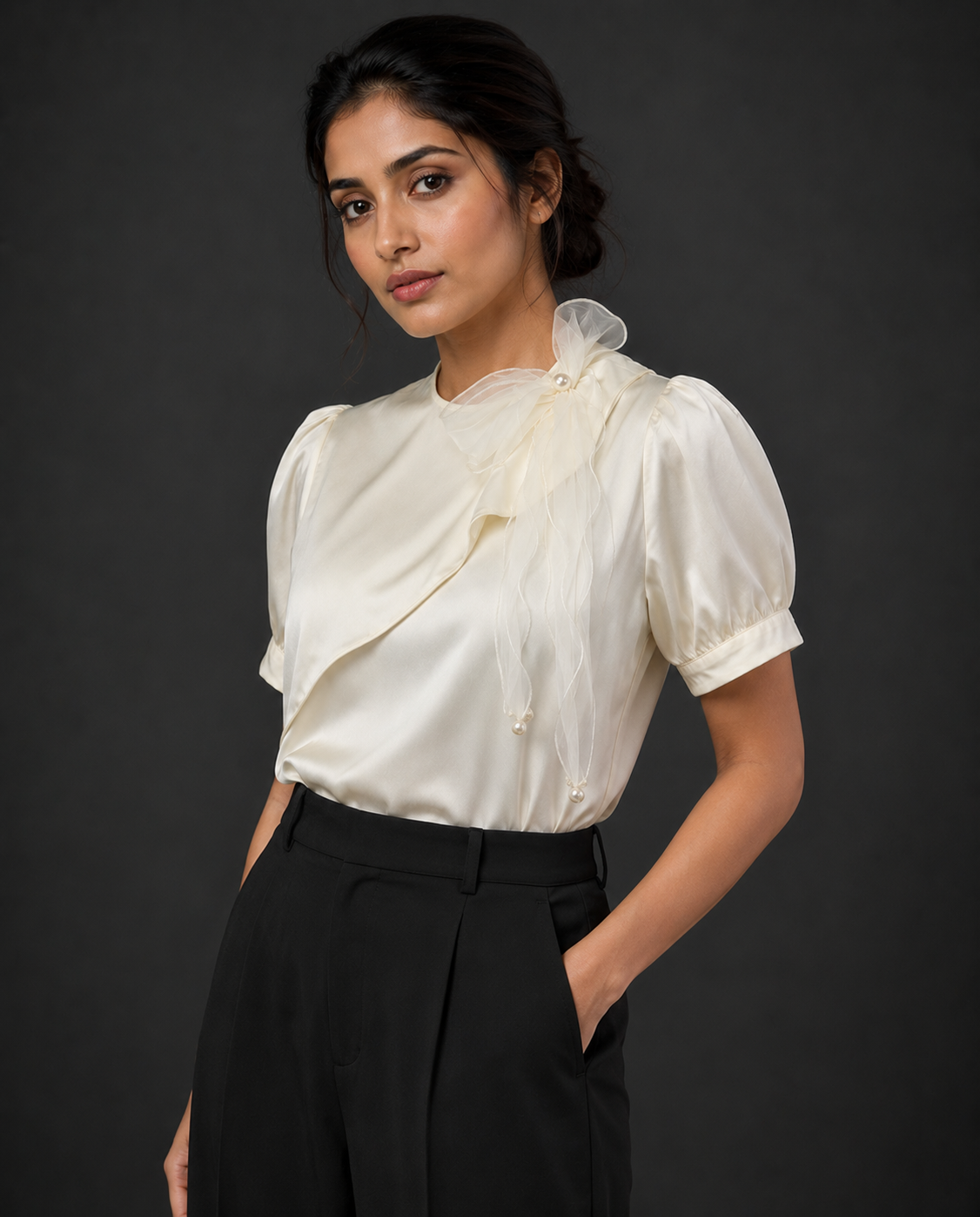 Woman wearing a white blouse with puffed sleeves against a dark background