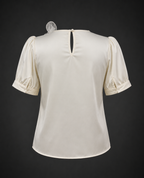 White blouse with puff sleeves on a dark background