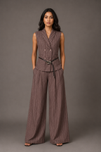 Woman wearing a brown pinstripe suit against a gray background