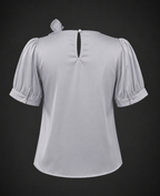 Light gray blouse with puff sleeves on a black background