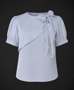Light blue blouse with puff sleeves on a black background