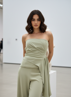 Woman wearing a strapless green dress in a minimalistic setting