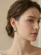 Close-up of a woman wearing earrings with a neutral background