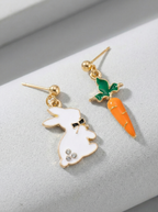 Pair of earrings with a rabbit and carrot design on a light gray background