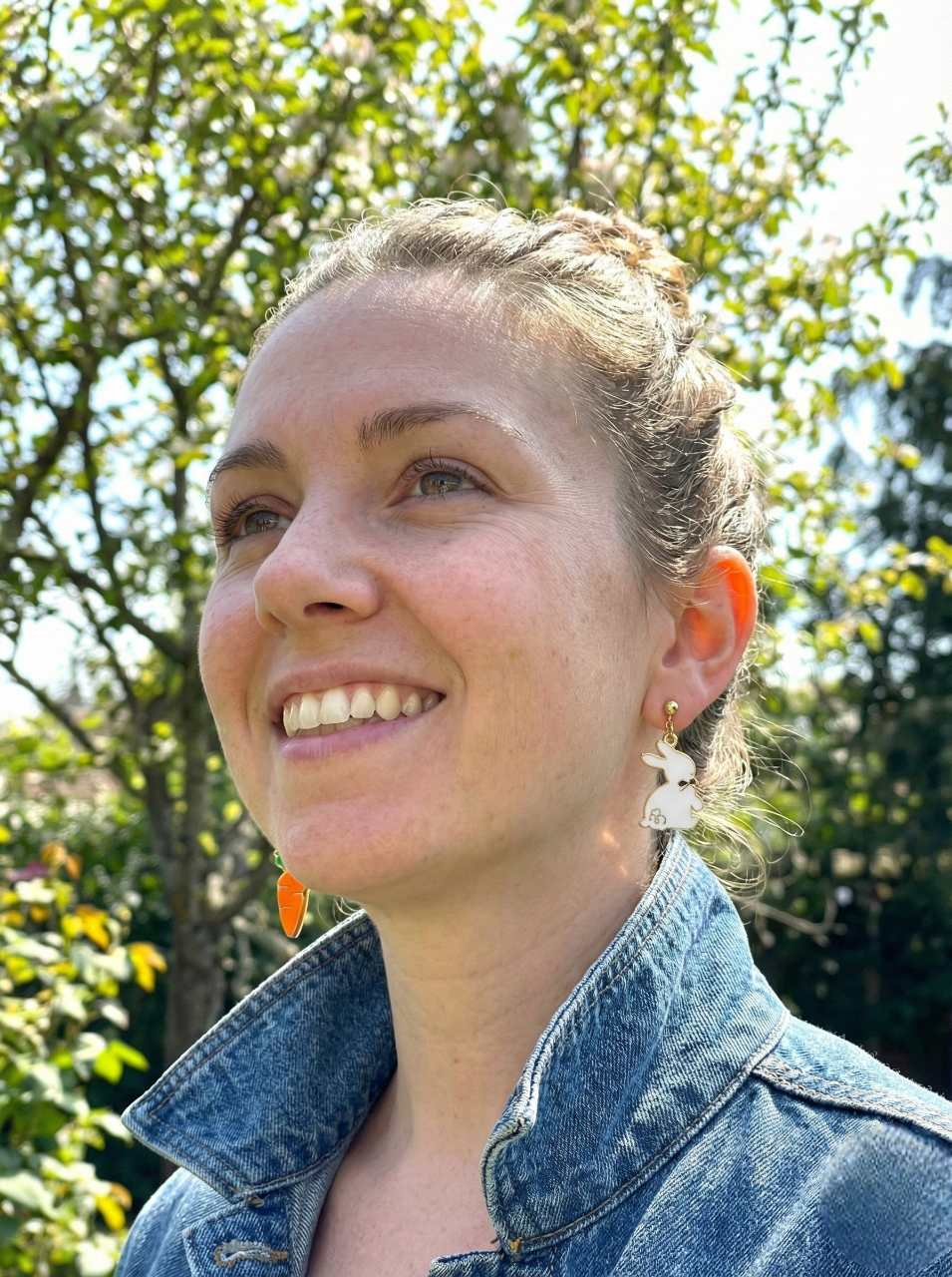 Woman wearing a denim jacket with trees in the background