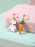 Pair of earrings with rabbit and carrot design on a pink and green background