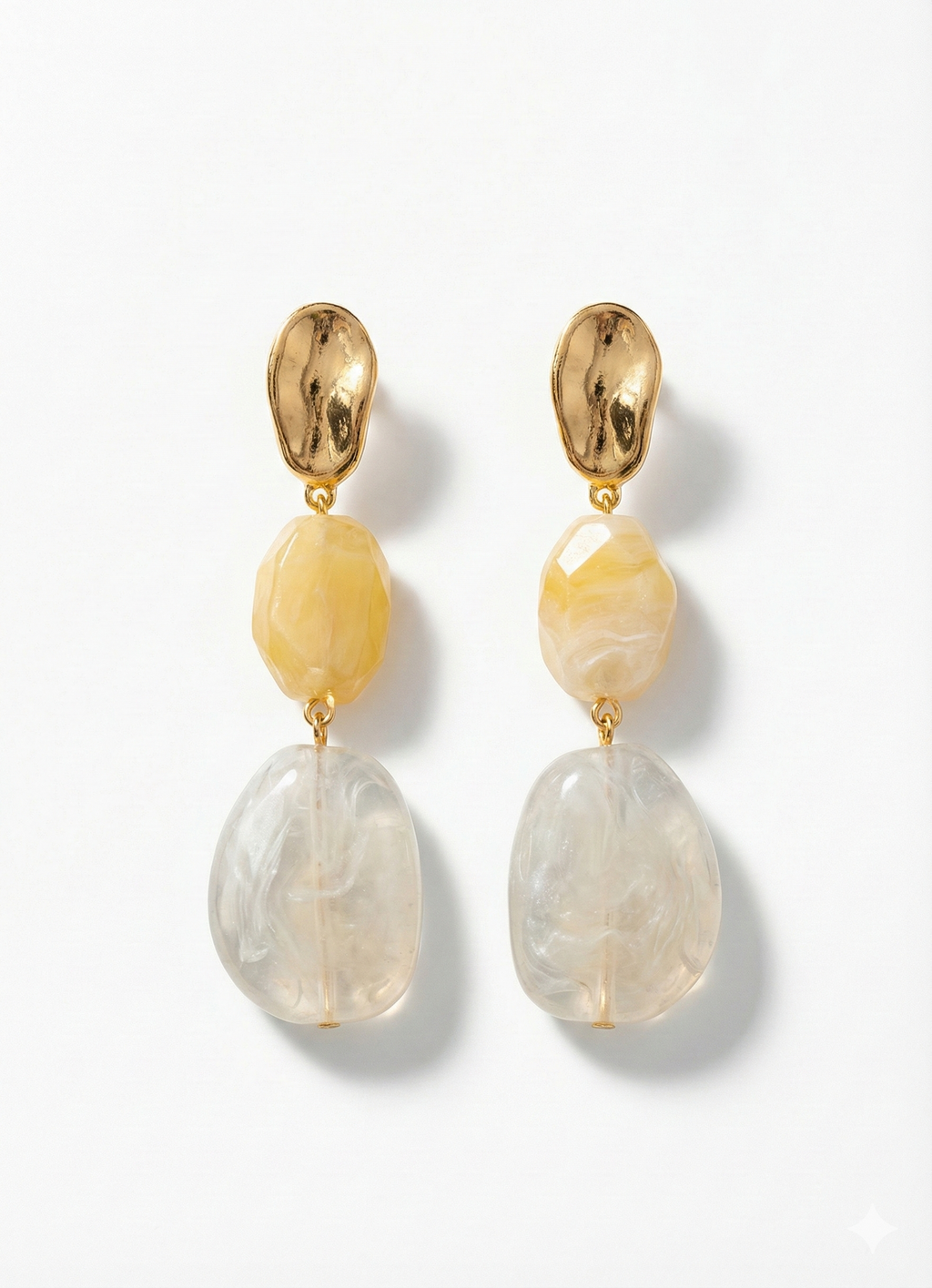 Pair of earrings with gold tops, yellow beads, and clear stone drops on a white background
