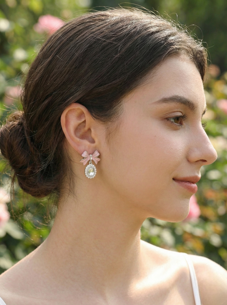 Woman wearing pink floral earrings with a blurred natural background