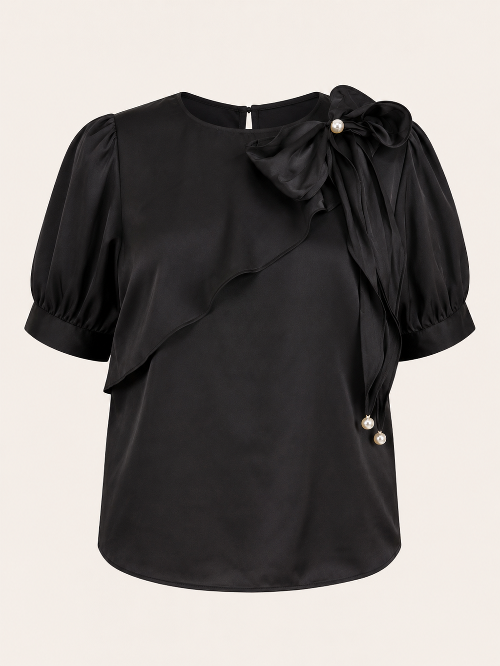 Black blouse with puff sleeves and pearl details on a beige background