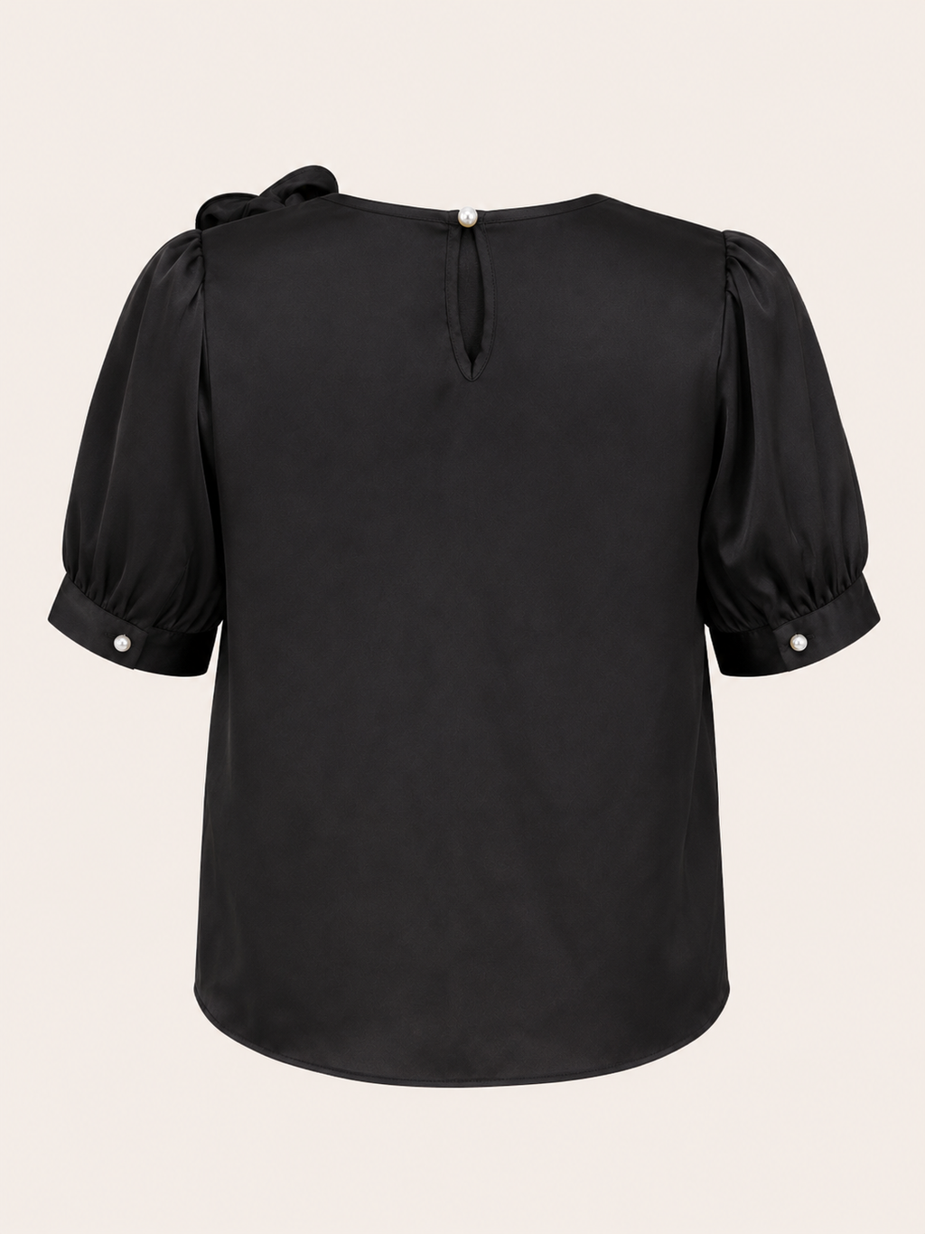 Black blouse with puff sleeves on a beige background