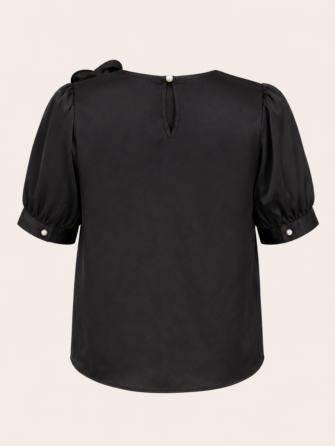 Black blouse with puff sleeves on a beige background