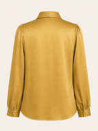 Yellow blouse with long sleeves on a light beige background
