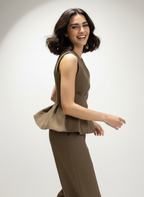 Woman wearing a brown sleeveless top and pants on a white background