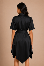 Woman wearing a black satin dress against a beige background