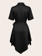 Black dress with a belt on a beige background