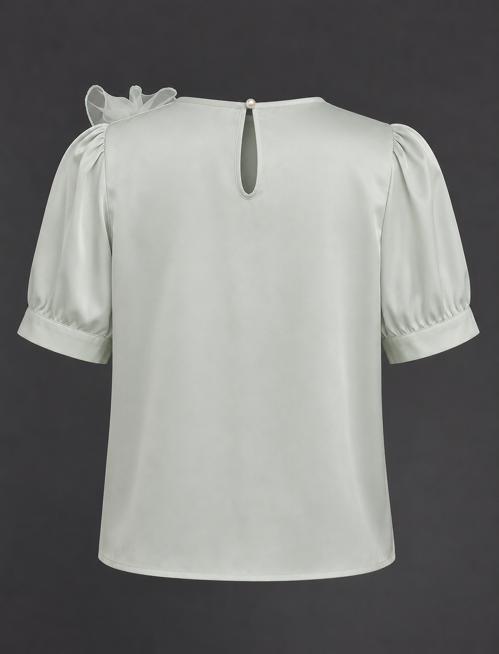 Light green blouse with puff sleeves on a dark background