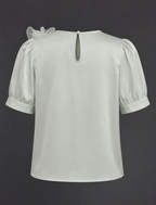 Light green blouse with puff sleeves on a dark background