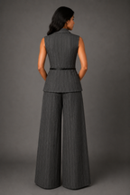Woman wearing a gray pinstripe suit with wide-leg pants against a gray background