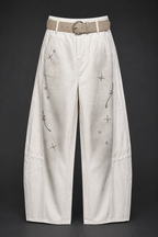 White pants with decorative elements on a black background