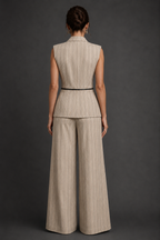 Woman wearing a beige pinstripe suit against a dark gray background