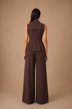 Woman wearing a brown sleeveless top and wide-leg pants against a beige background