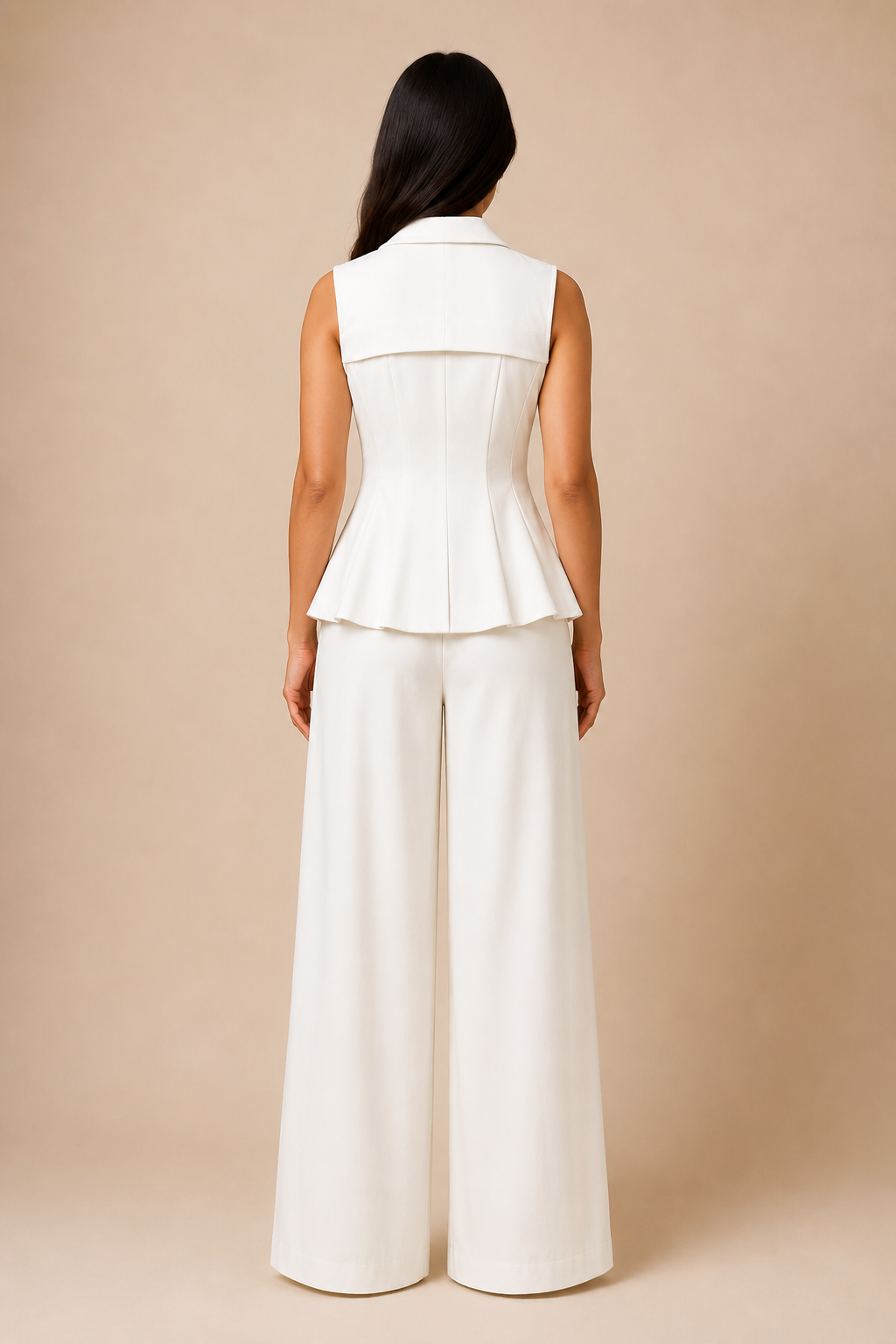 Woman wearing a white sleeveless top and wide-leg pants against a beige background