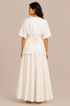 Woman wearing a white dress against a beige background