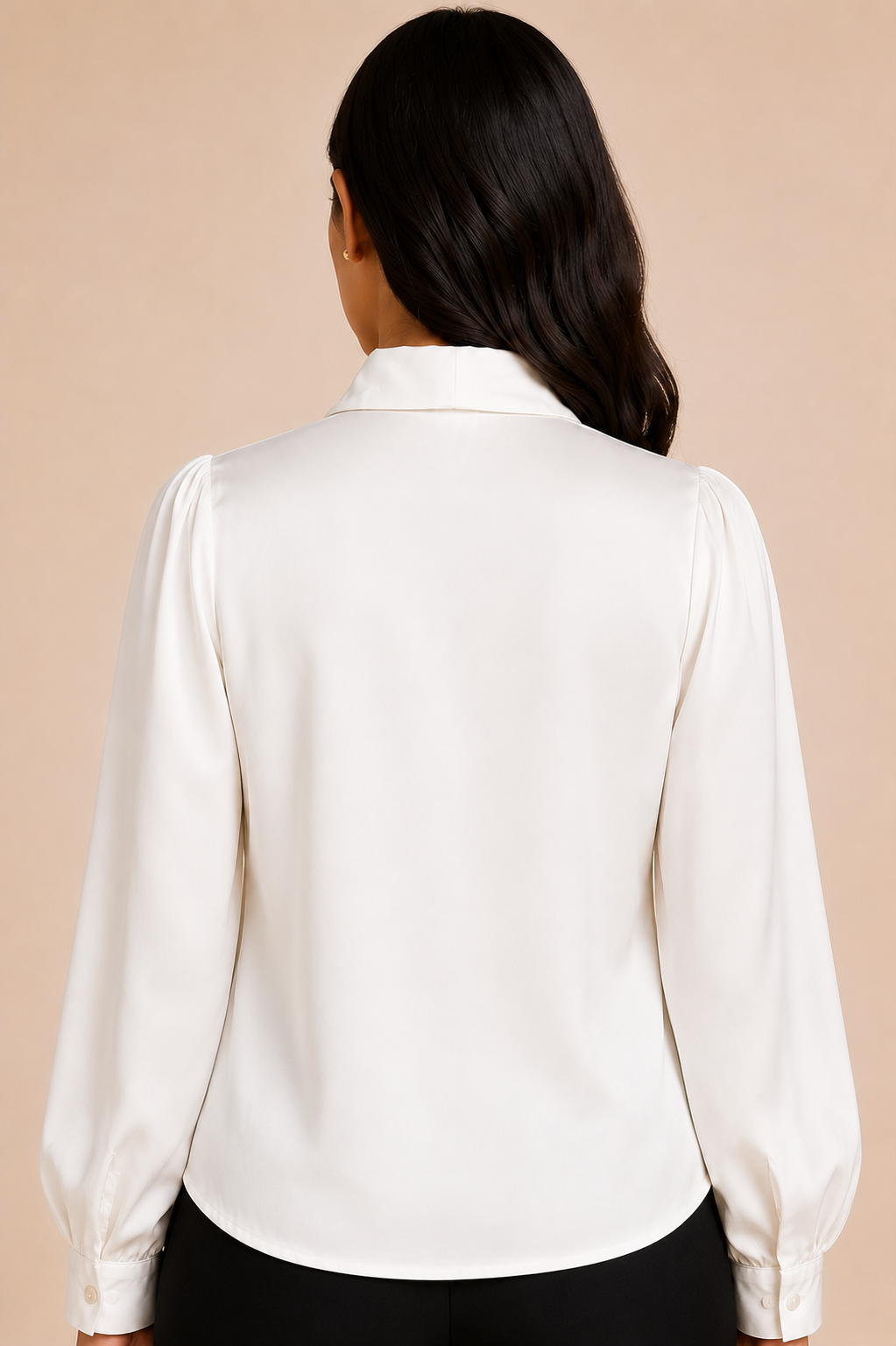 White blouse with long sleeves worn by a person on a beige background