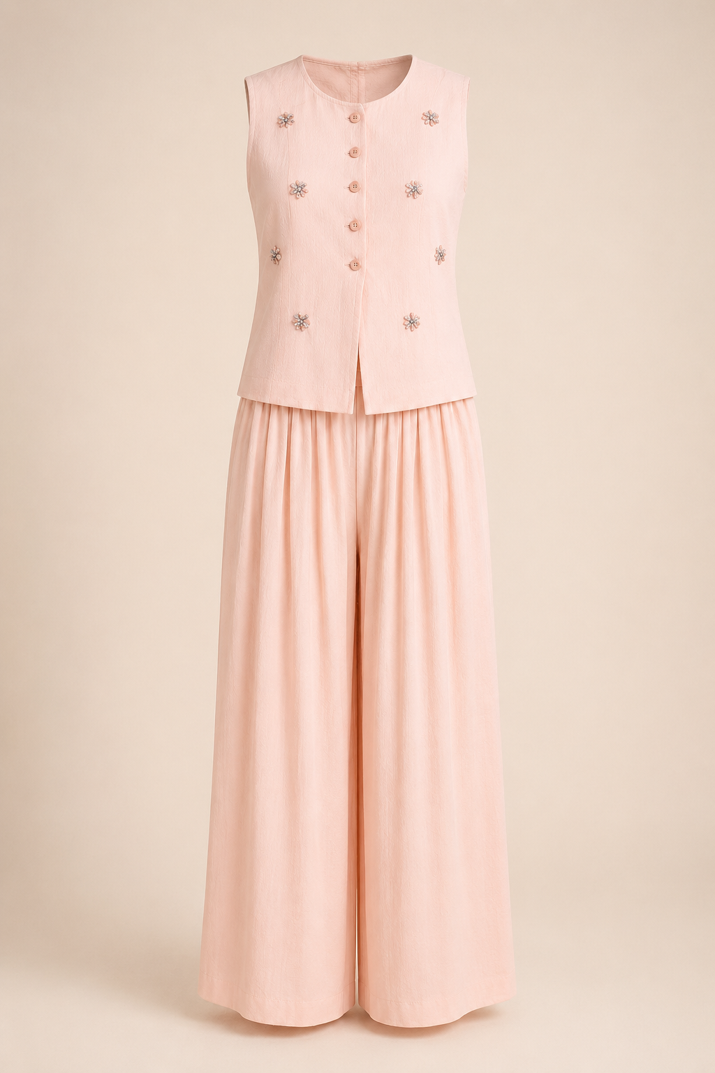 Light pink traditional outfit with a top and wide-leg pants on a beige background