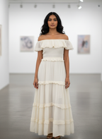 Woman wearing a white off-shoulder dress in an indoor setting