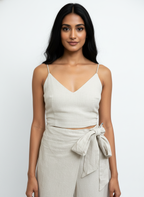 Woman wearing a white top and beige wrap skirt on a white background