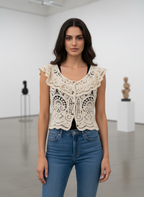 Woman wearing a lace top and blue jeans in an indoor setting
