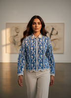 Woman wearing a blue embroidered jacket in an art gallery setting
