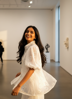 Woman in a white dress standing in an art gallery